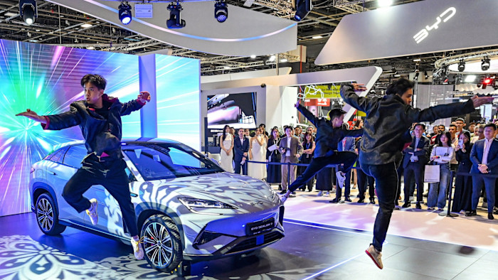 Martial artists perform in front of a BYD Sealion 7 electric vehicle at the Singapore Motorshow, with a colorful digital backdrop and an audience watching