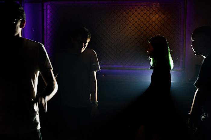 Four young people dance at in a dark room with strobe lights. The photograph was taken in 2016 at one of Shanghai’s leading underground clubs, The Shelter 
