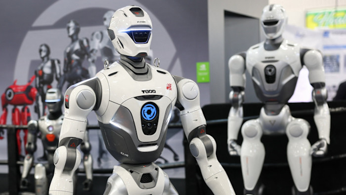 The EngineAI T800 humanoid robot is displayed at CES, with other humanoid and robotic models visible in the background.