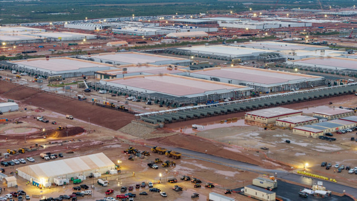 Rows of large, low buildings and construction vehicles at the Stargate AI data center site in Abilene, Texas.