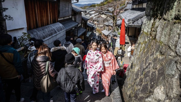 Crowds make their way through a street near Kiyomizu-dera, a Buddhist temple in Kyoto