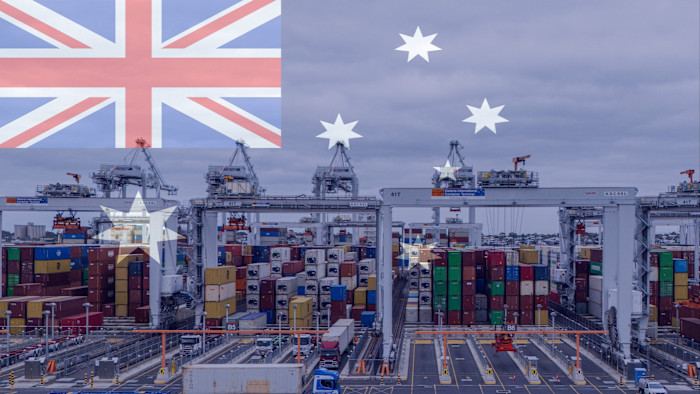 Stacks of shipping containers and cranes at the Victorian International Container Terminal, with the Australian flag overlaid.