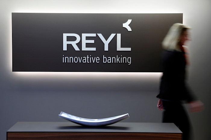 A person walks past a sign reading “REYL innovative banking” inside the Reyl & Cie headquarters in Geneva.