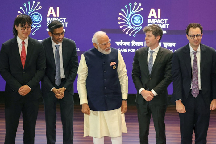 Narendra Modi stands with Alexandr Wang, Sundar Pichai, Sam Altman, and Dario Amodei.