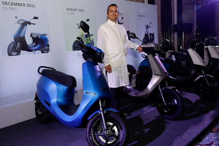 Bhavish Aggarwal, founder of Ola Electric, poses with electric scooters