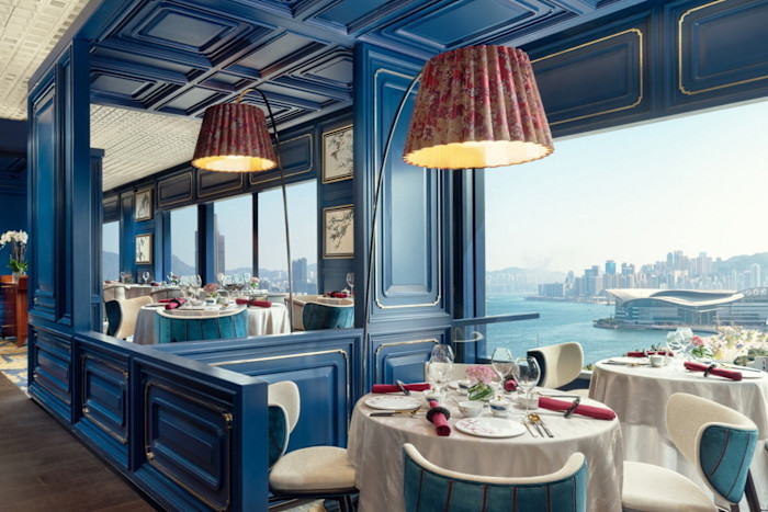 Detail of the hotel’s Man-Wah restaurant, with tables set amid a royal blue decor and views over the harbour and city skyline.