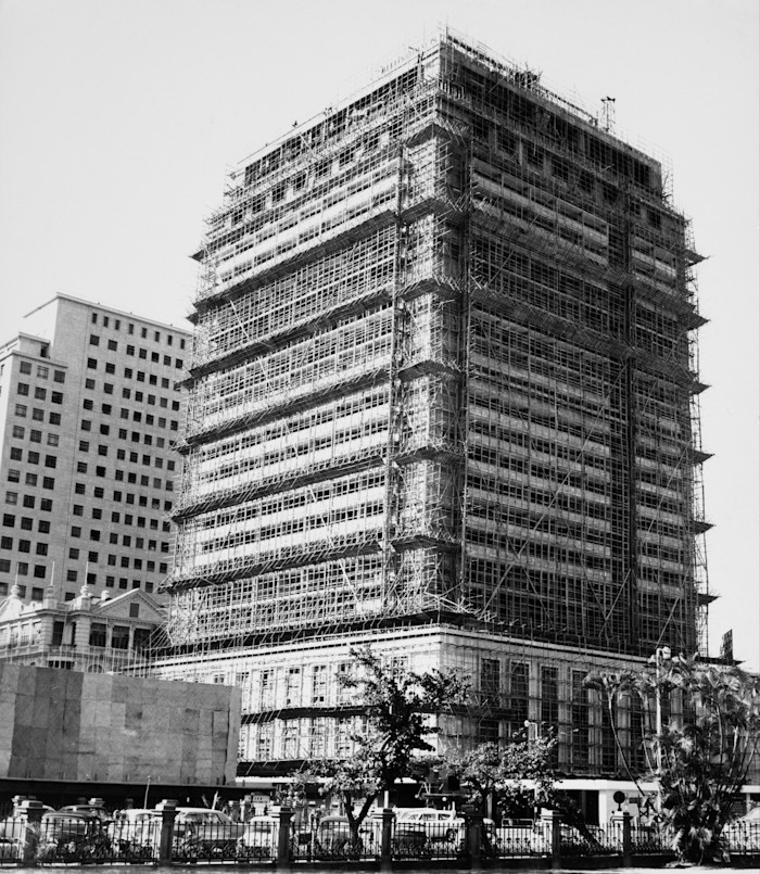 The Mandarin Oriental hotel covered in scaffolding during construction in Central District, Hong Kong, circa 1963.