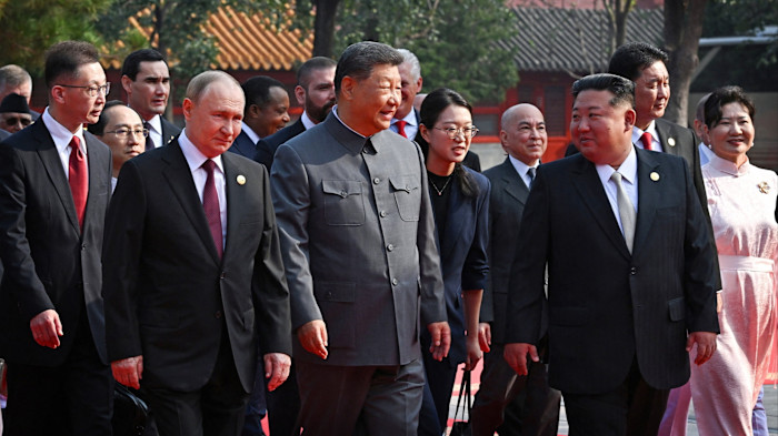Vladimir Putin, Xi Jinping and Kim Jong Un walk together among other foreign delegates at a military parade in Beijing