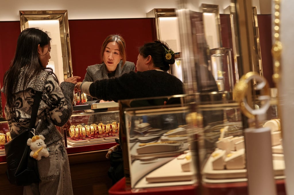 A customer tries a gold bracelet at a jewellery store in Hong Kong. Photo: Reuters