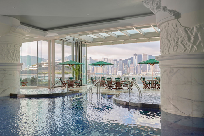 Two white columns with a ‘crumbling’ effect and circled by friezes of male figures in the hotel’s ancient Rome-inspired indoor pool, which looks through floor-to-ceiling windows over the Hong Kong skyline.