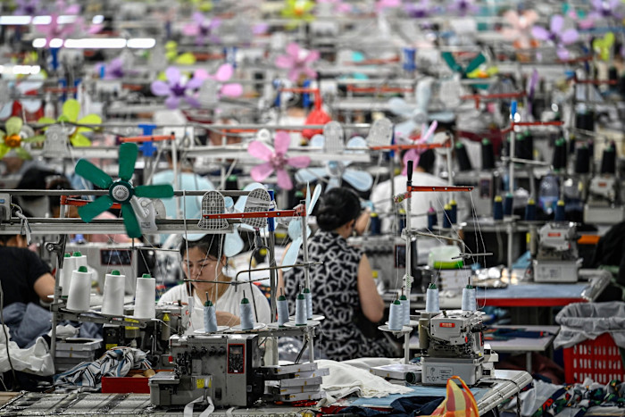 Rows of textile workers sat at sewing machines make products for Shein at a factory in Guangzhou, China