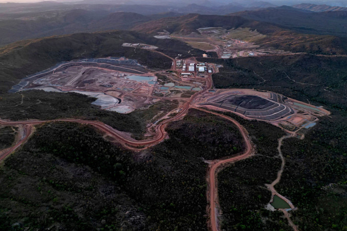 Aerial view of the Serra Verde Mining rare earth elements mine, showing open pits, tailings, and industrial facilities surrounded by hills.