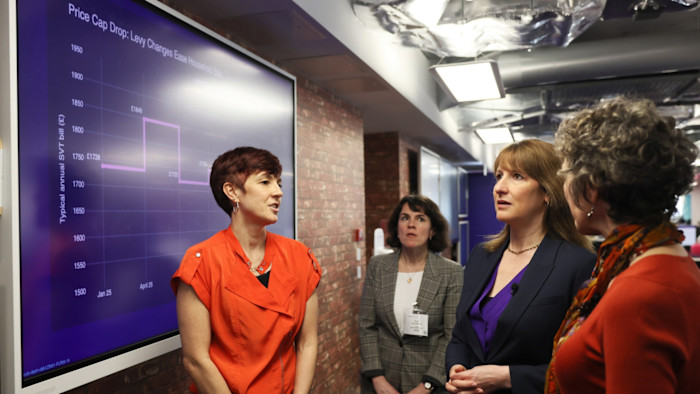 Rachel Reeves, Rebecca Dibb-Simkin, and Rachel Fletcher view a chart showing a drop in typical household energy bills.