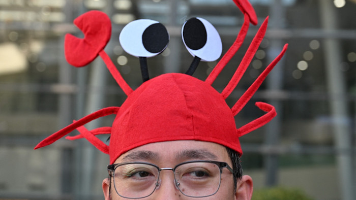 A man wearing glasses dons a red lobster hat with large cartoon eyes and claws, representing the OpenClaw logo