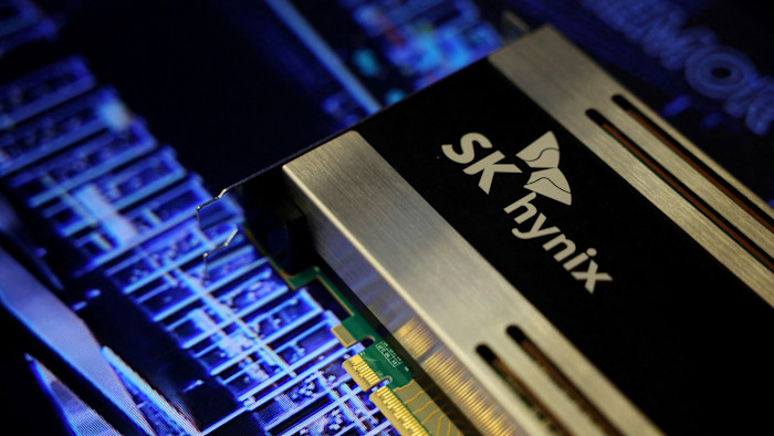 Close-up of an SK Hynix semiconductor product with the company logo visible, displayed against a blue-lit circuit board background.