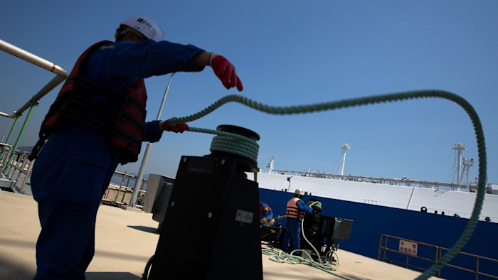A port worker helps tie up an LNG tanker at a terminal in South Korea.