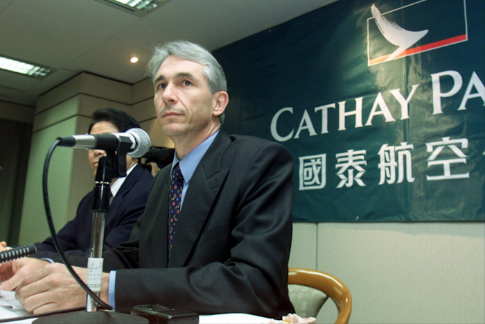 Tony Tyler speaks at a news conference beside a Cathay Pacific banner in 2001.