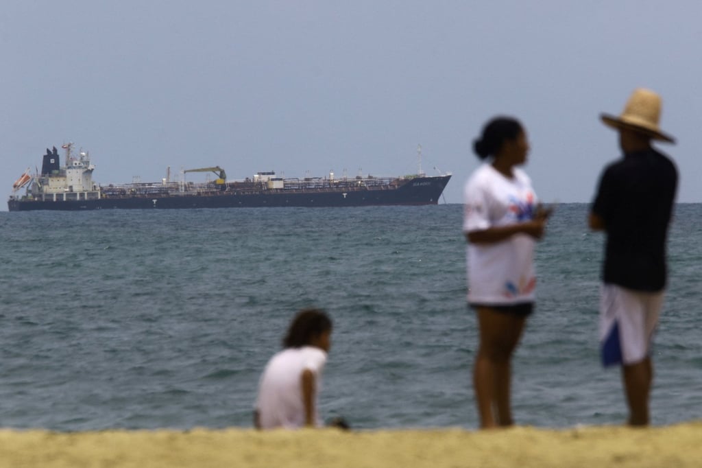 People stand on the beach as the Hong Kong-flagged Sea Horse, carrying Russia-origin fuel originally bound for Cuba, is anchored in Puerto Cabello, Venezuela on Saturday. Photo: Reuters