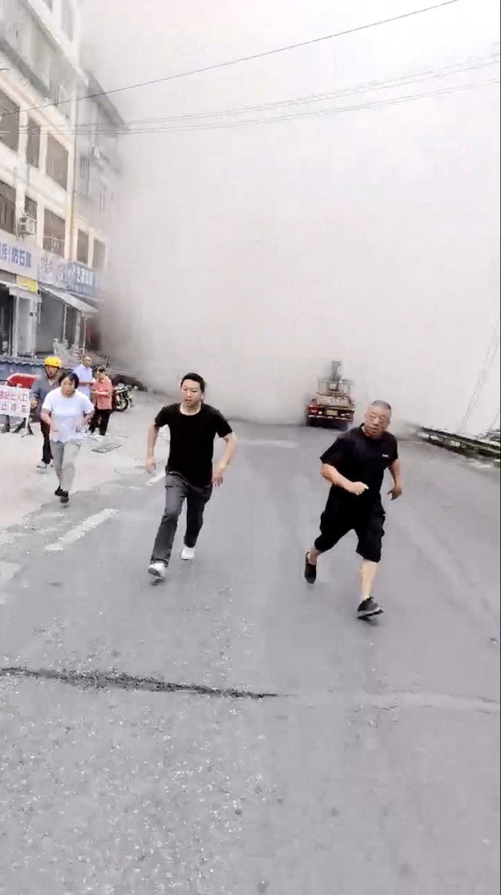 A social media video taken in Chongqing shows people away from a cloud of dust rising as buildings collapse due to a landslide. Photo: social media via Reuters A social media video taken in Chongqing shows people away from a cloud of dust rising as buildings collapse due to a landslide. Photo: social media via Reuters