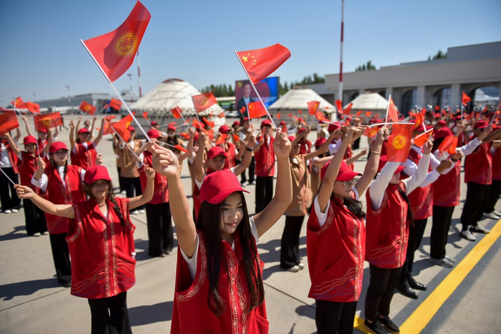 Kyrgyz performers wave Chinese flags as Chinese President Xi Jinping and his wife Peng Liyuan arrive in Bishkek, Kyrgyzstan, on August 30. Photo: Kyrgyzstan’s Presidential Press Office via AP